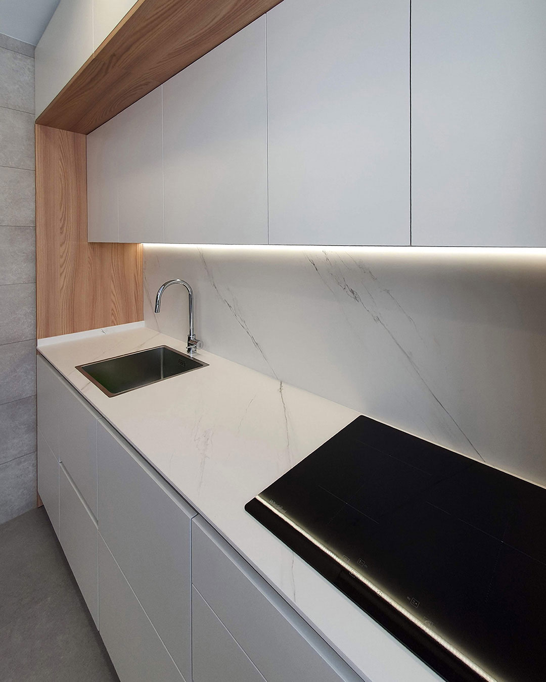 Cocina moderna con isla central, acabados en tonos neutros y elementos de madera natural