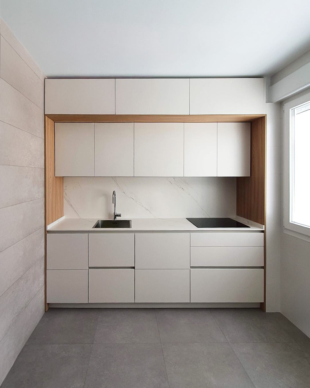 Cocina moderna con isla central, acabados en tonos neutros y elementos de madera natural