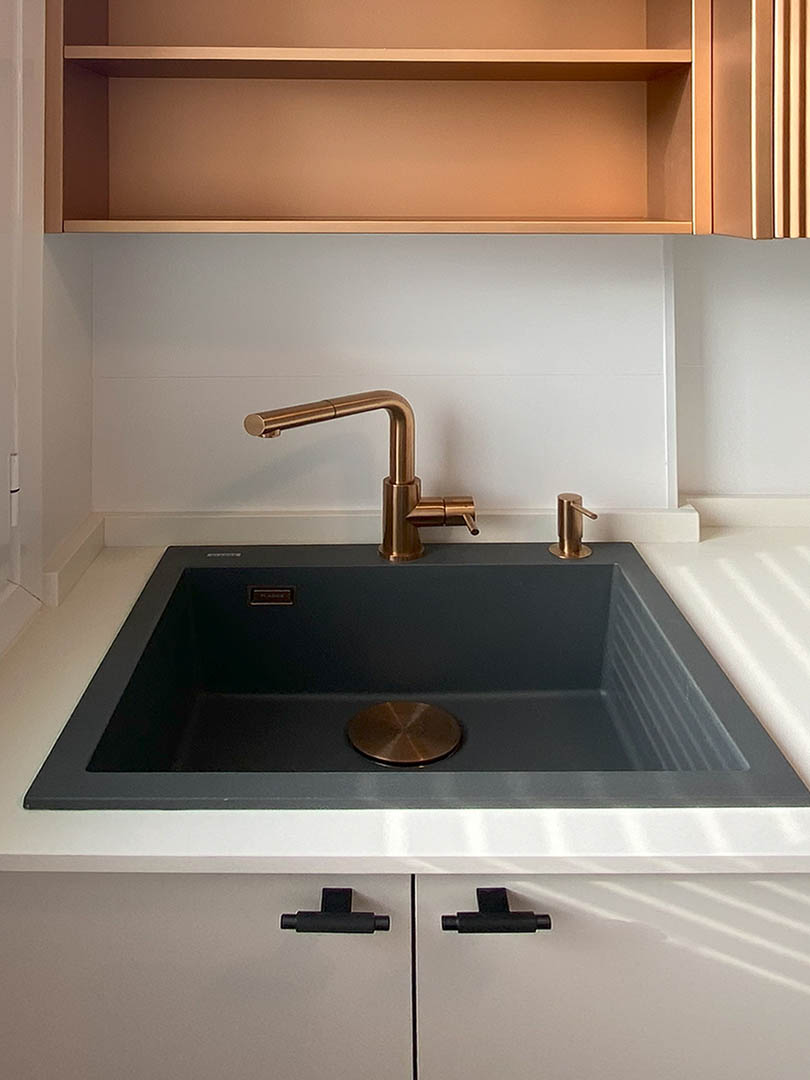 Zona de preparación con encimeras de gran formato y muebles superiores con acabado ranurado