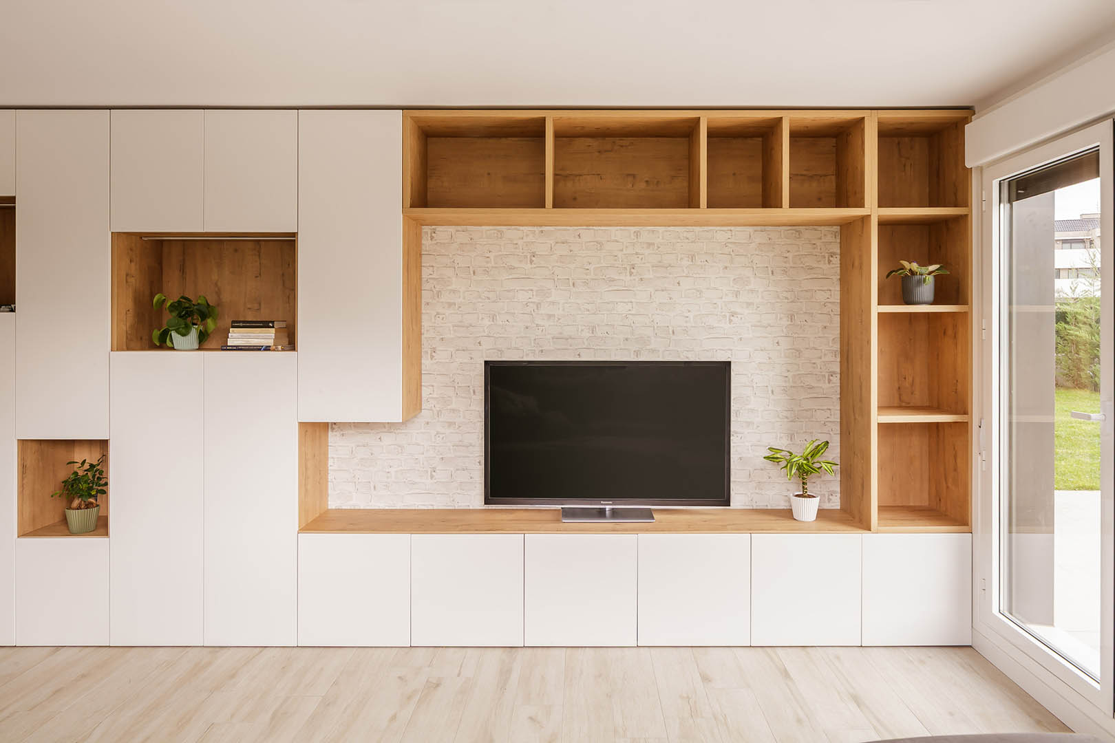 Zona descalzadora con mueble a medida de almacenaje en tonos claros y acabados en madera natural