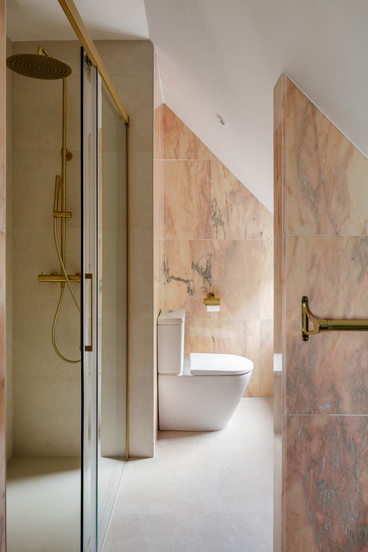 Baño principal con mueble suspendido blanco de doble lavabo, espejos circulares y ventanal con luz natural