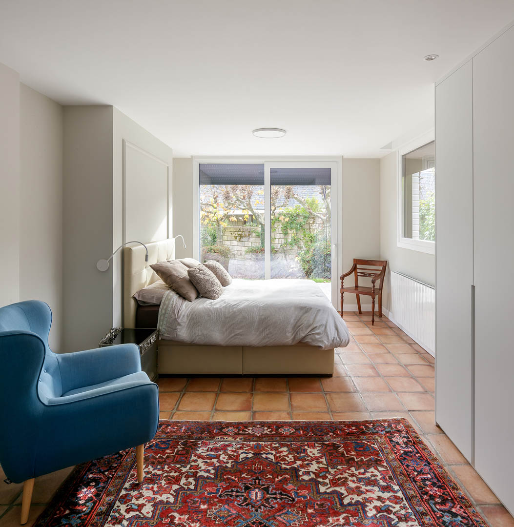 Vista exterior de vivienda reformada con carpintería PVC color verde musgo contrastando con fachada blanca