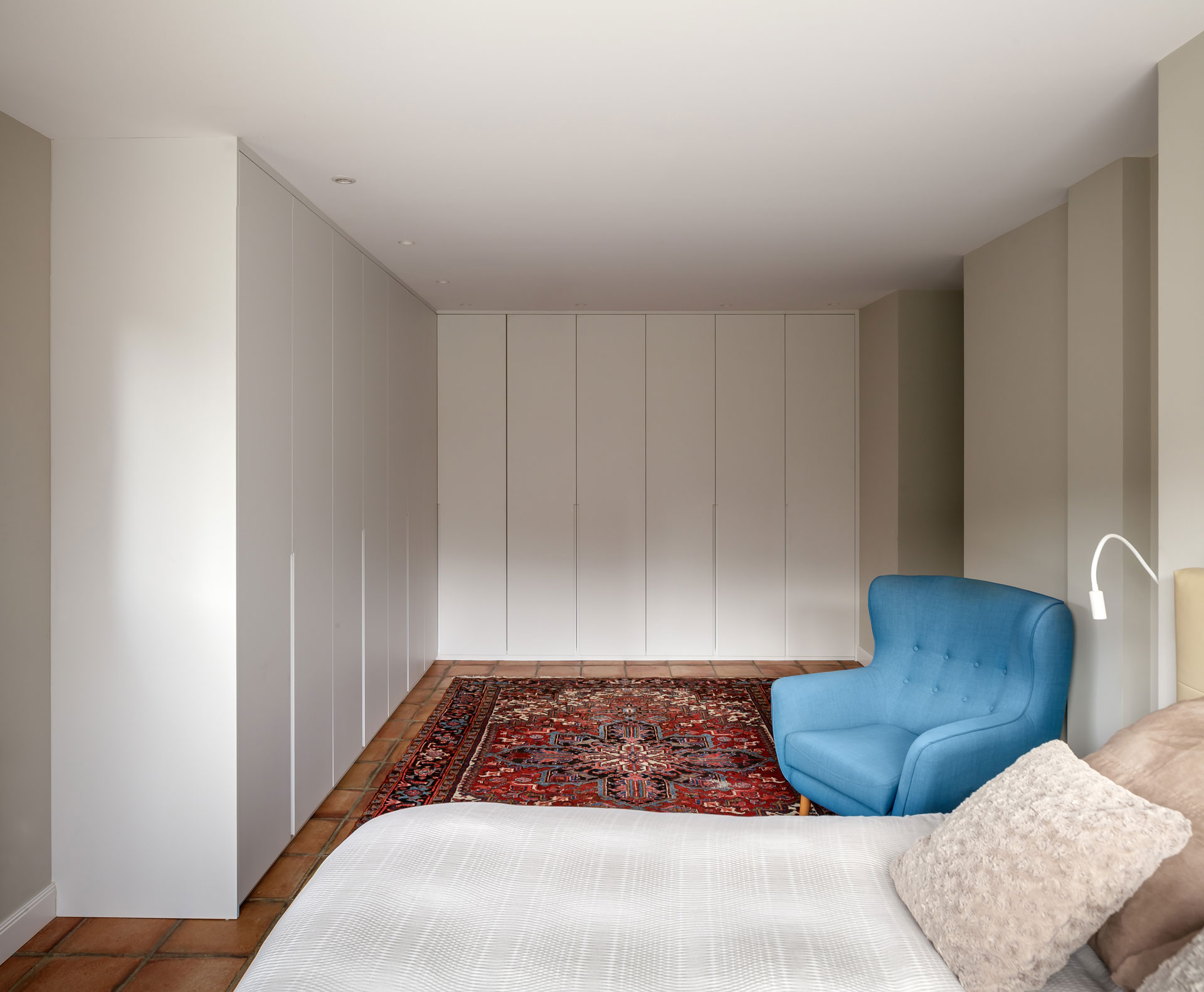 Armarios empotrados a medida con frentes lacados en blanco mate y líneas depuradas integrados en pasillo