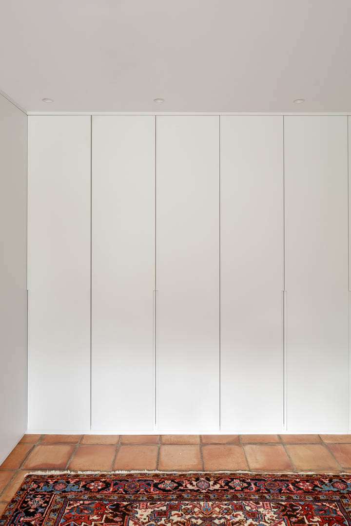 Armario de baño principal a medida con zona de estantería abierta y almacenaje cerrado integrado