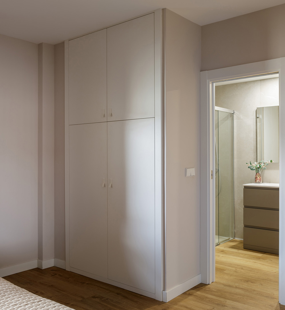 Vestidor OLLER 07 con armario en L a medida, frentes lacados blancos mate, organización interior personalizada con barras, baldas y cajones, diseño funcional y estética serena