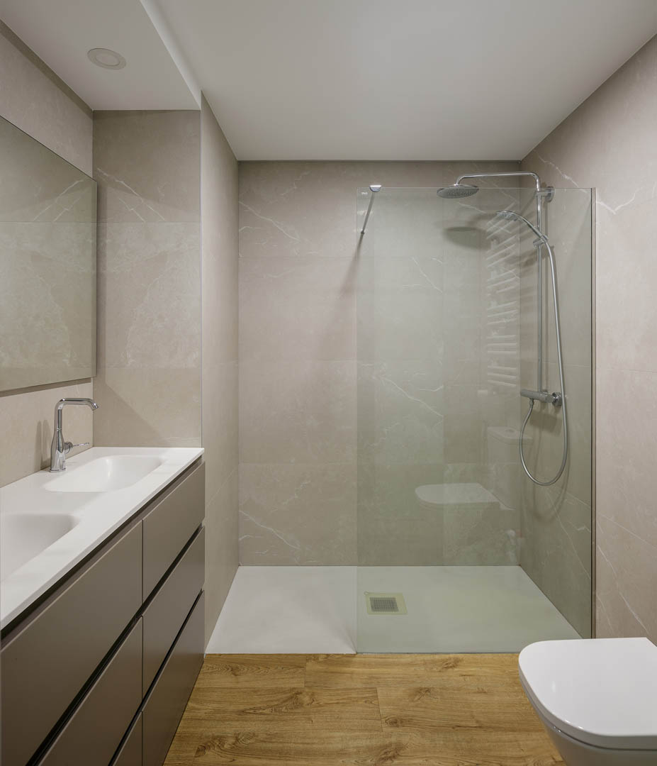 Bañera exenta independiente con revestimiento azulejo tipo metro blanco a media altura, lámpara de araña decorativa clásica y diseño atemporal en baño principal OLLER 07