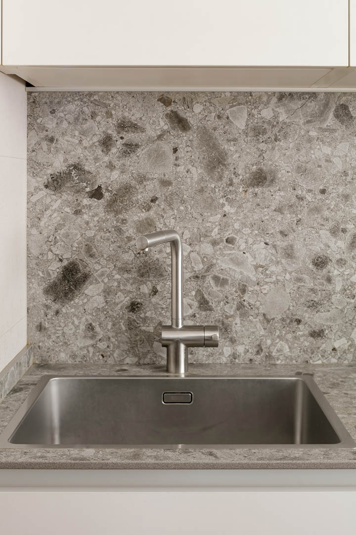 Salón amplio OLLER 07 con zonas definidas claramente, librerías integradas a medida, mobiliario cálido y armonía visual en planta baja de reforma interior