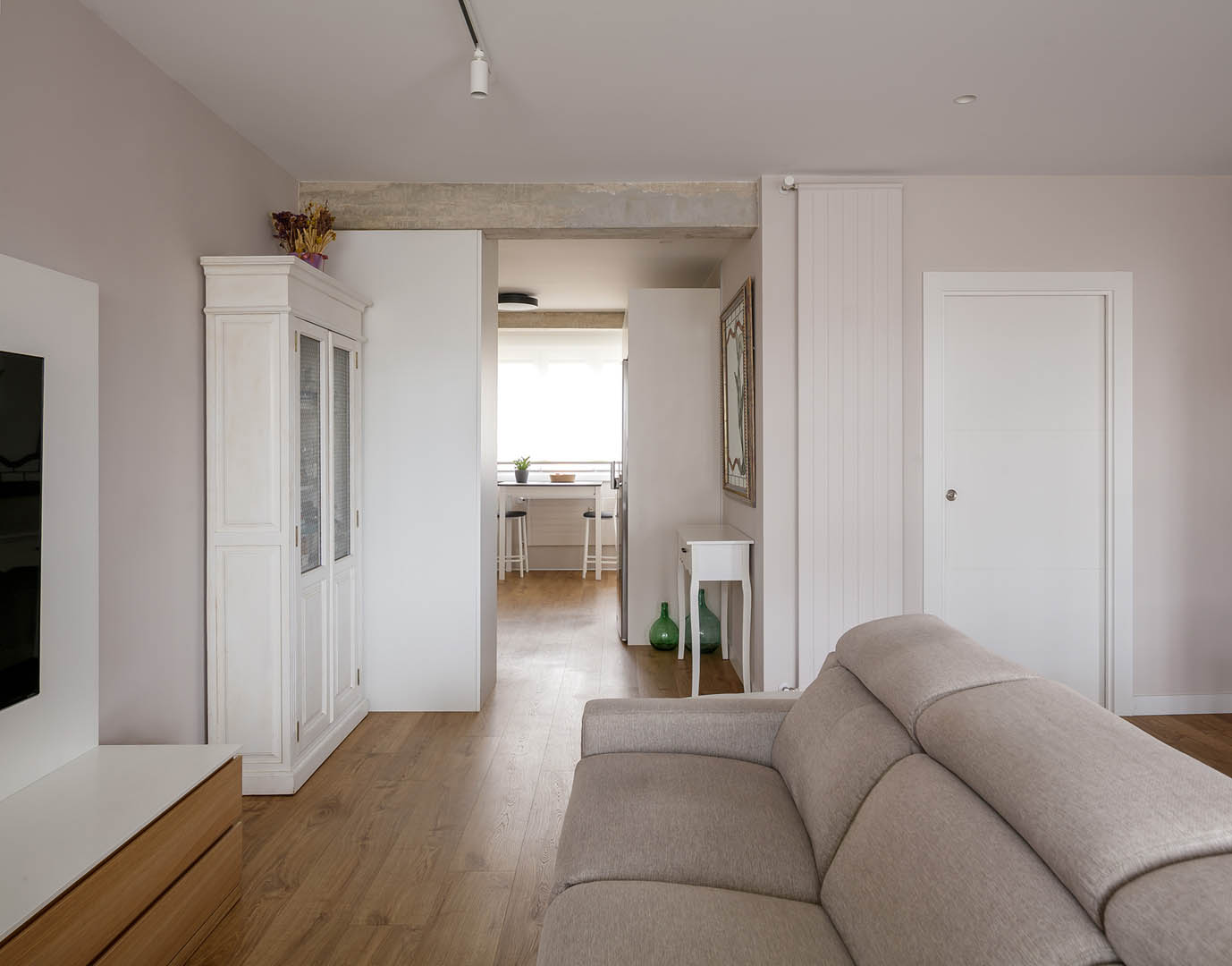 Vista exterior de vivienda reformada con carpintería PVC color verde musgo contrastando con fachada blanca