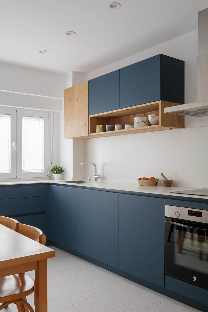 Salón amplio OLLER 08 con zonas definidas claramente, librerías integradas a medida, mobiliario cálido y armonía visual en planta baja de reforma interior